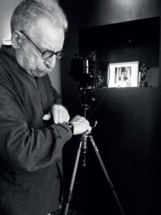 Giovanni Chiaramonte mentre fotografa l’ultima teca della mostra Peninsula con la sua fotografia Interno morto alla galleria Lorenzo Vatalaro, Milano, 2017. Foto Lorenzo Vatalaro